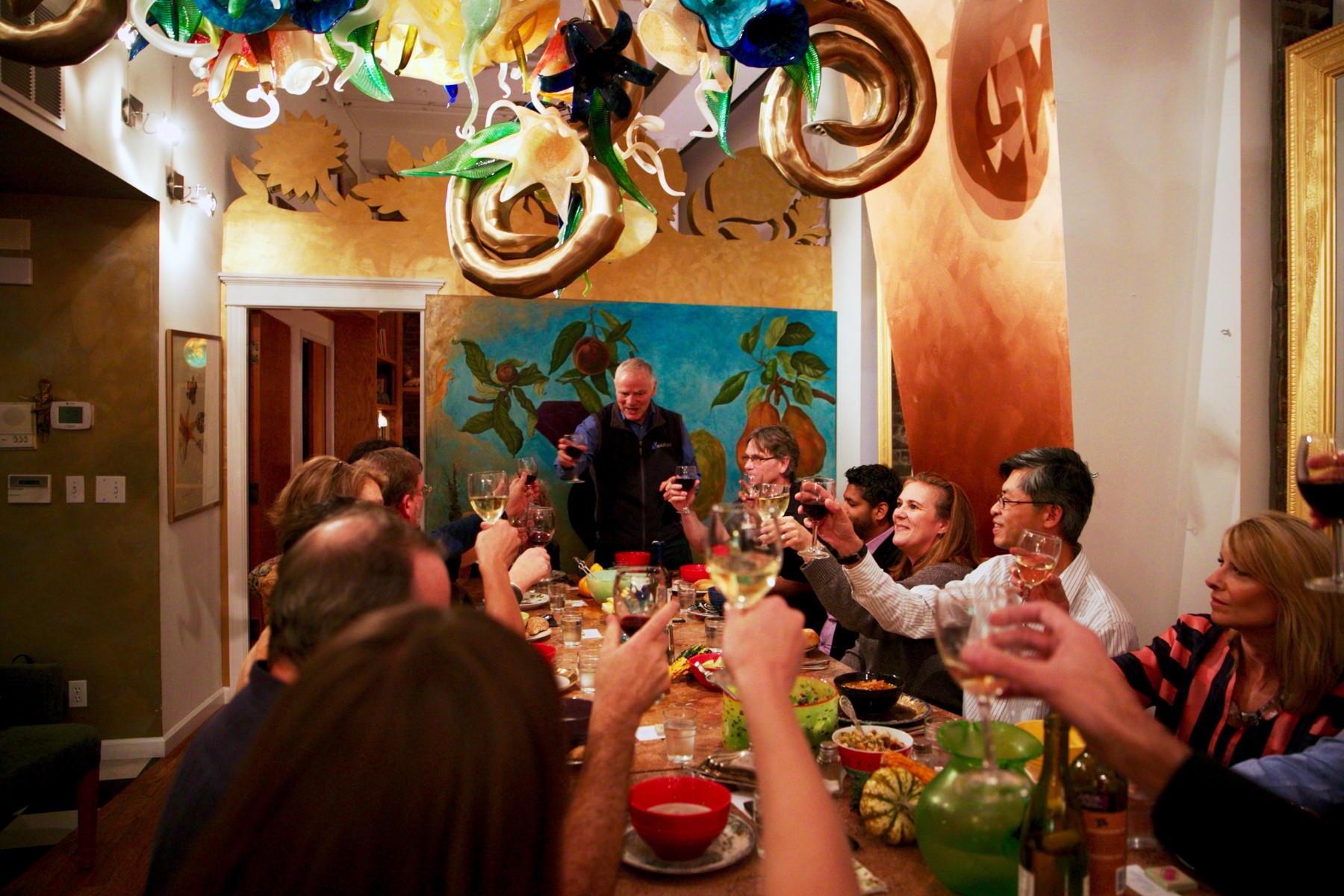 ISB President Dr. Lee Hood raises a toast to ISB's Consilience Program during an event at artist Ginny Ruffner's home.