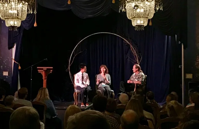three people giving a presentation on a stage