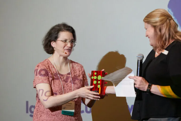 two women on a stage presenting an award